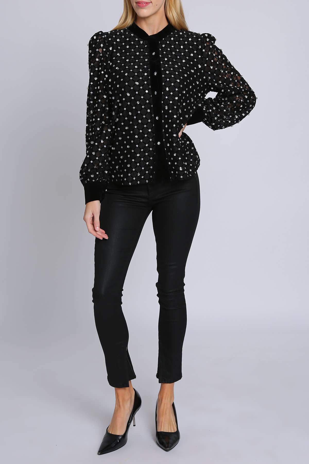 woman wearing black blouse with rhinestone embellisment and black leggings and black heels