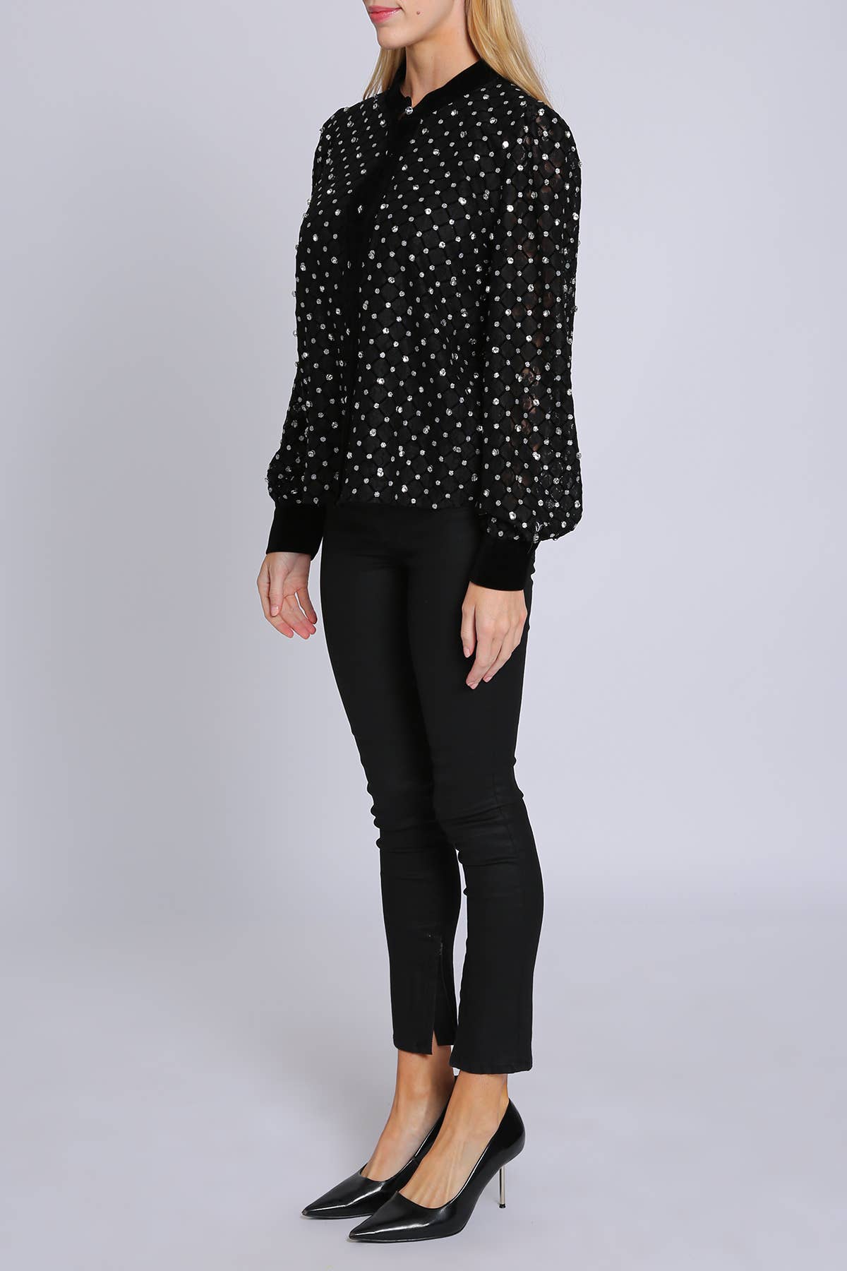 woman wearing black blouse with rhinestone embellisment and black leggings and black heels