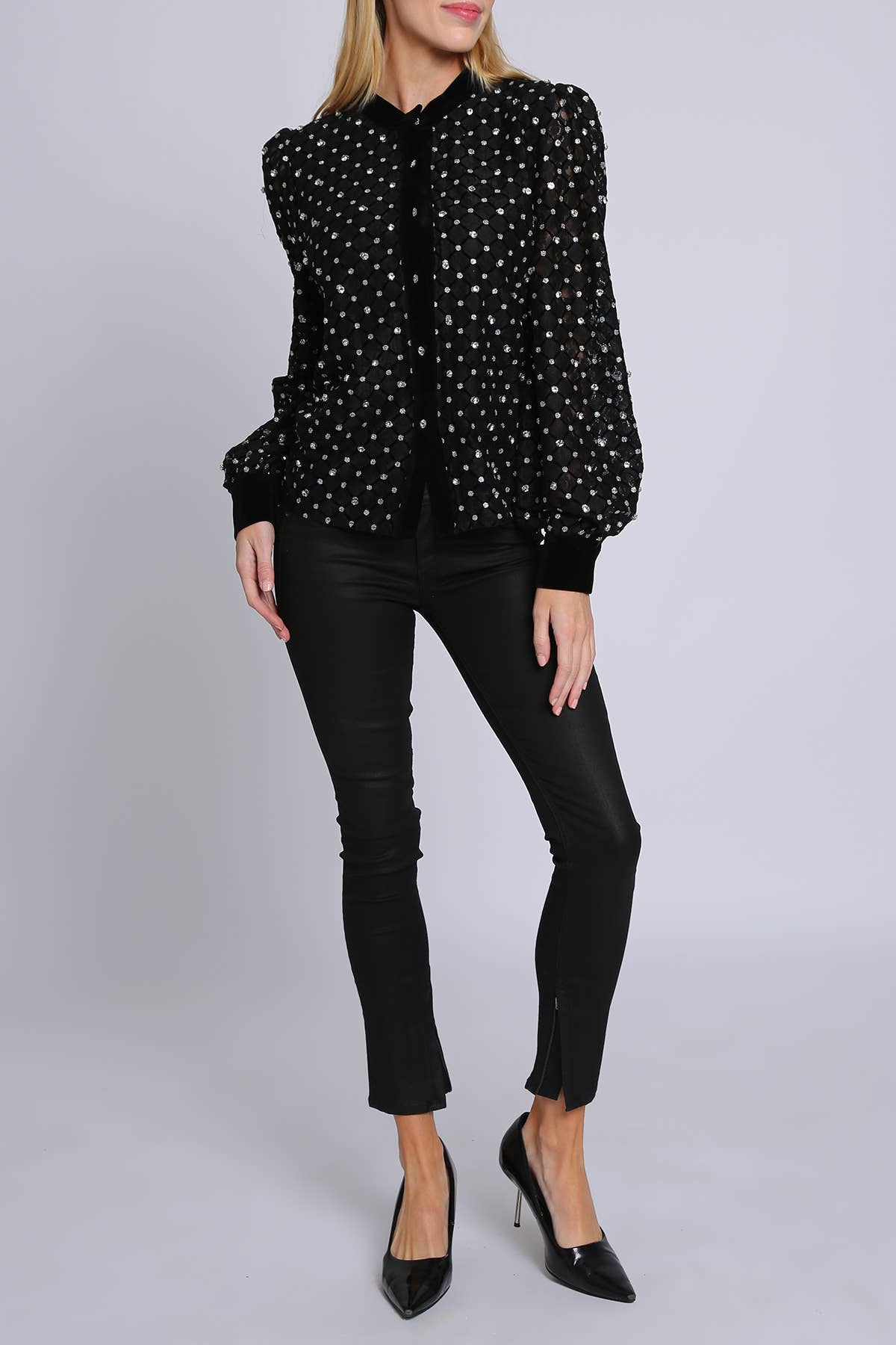 woman wearing black blouse with rhinestone embellisment and black leggings and black heels