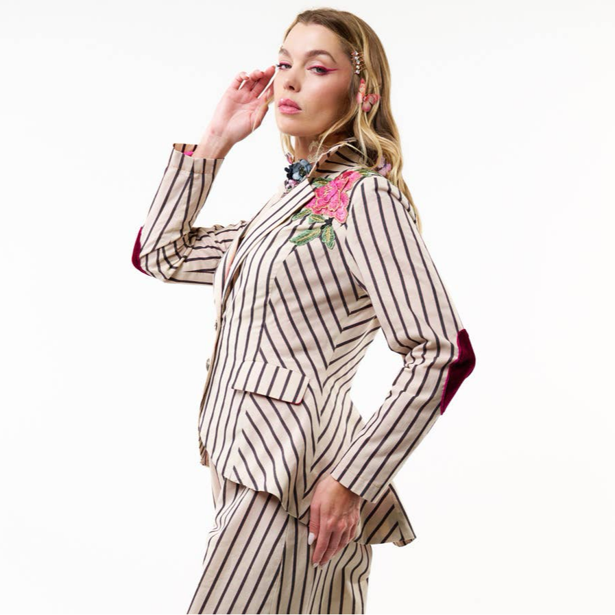 side view of woman wearing black and cream striped blazer with floral embellishment