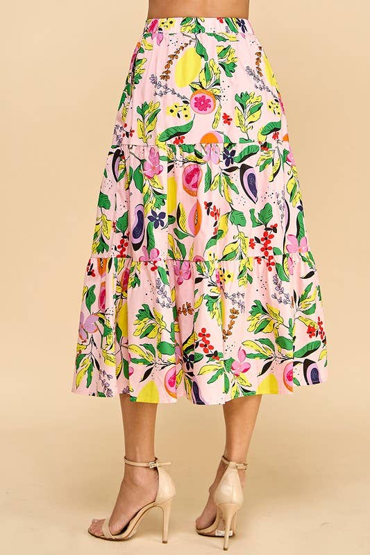 back view of woman wearing a fruit and floral printed skirt with tan strappy heels