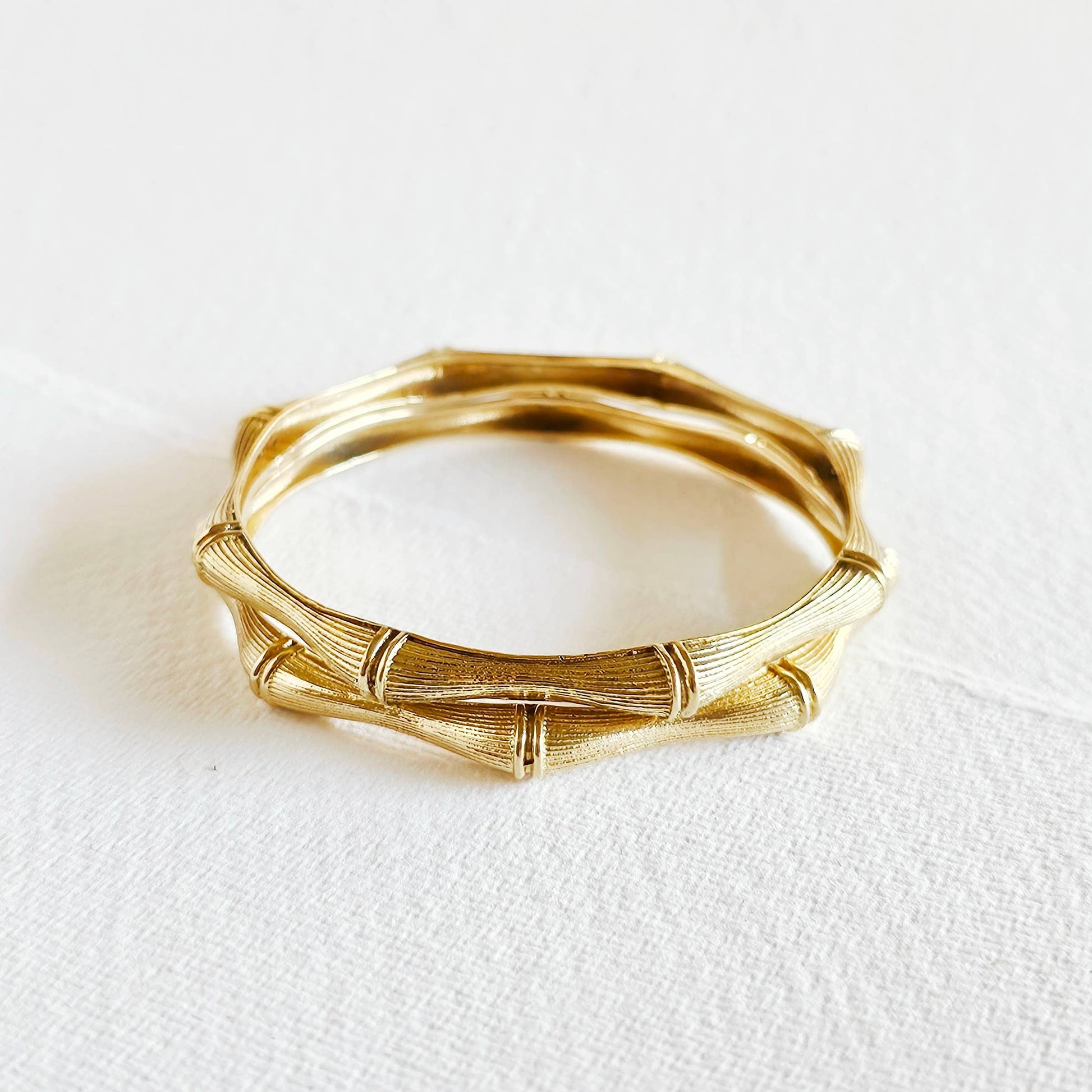 pair of brass bamboo shaped bangle bracelets against a white background