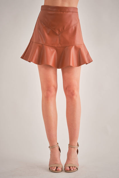 woman wearing a short brown vegan leather skirt with tan heels